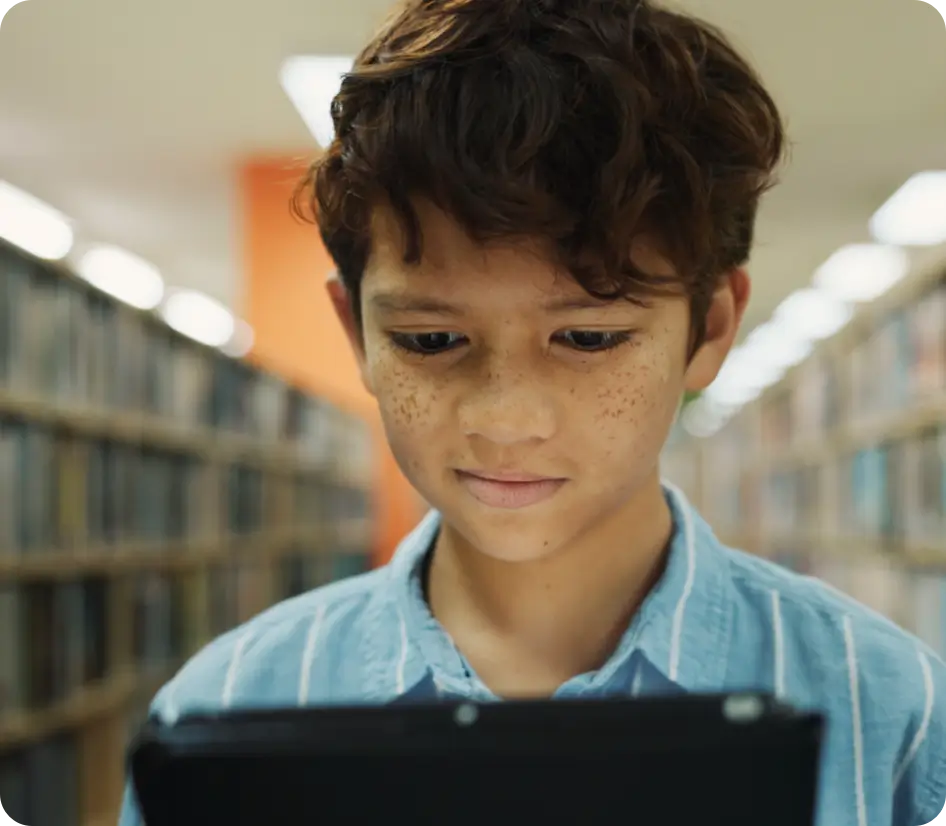 Student reading on a tablet in a library.