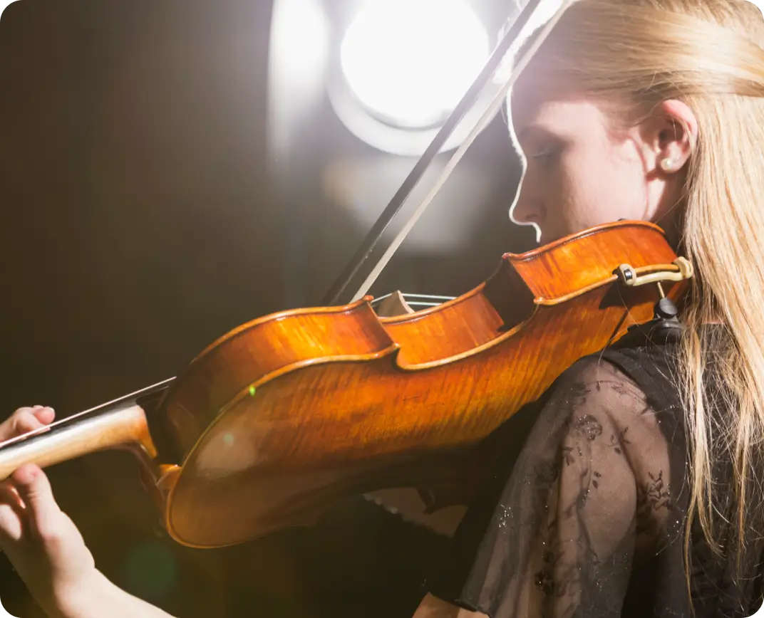 Young woman playing the violin on stage.