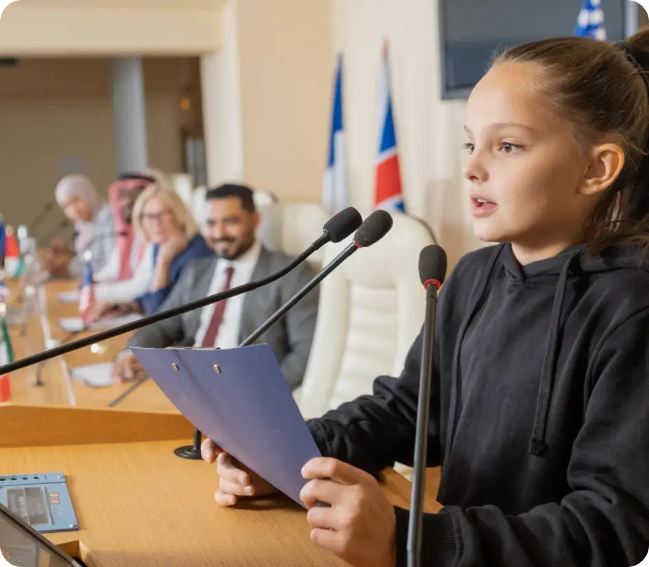 Student speaking at microphones during a public meeting.