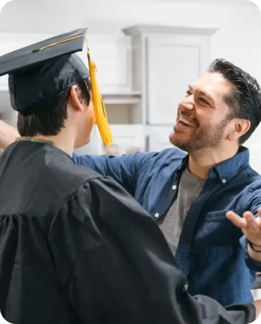 Man congratulating a graduate in a cap and gown.